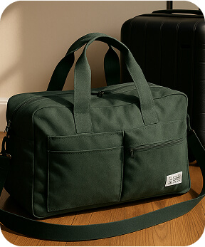Dark green recycled travel duffle next to suitcase on floor